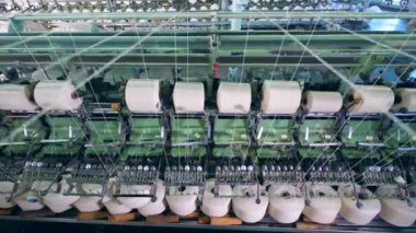 Dönen ekipman, bir tekstil fabrikasında beyaz lif ile cocuk.