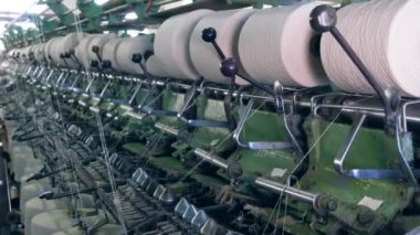Tekstil fabrikası makineleri, iplik bobinleri ile çalışır. Endüstriyel Tekstil Fabrikası.