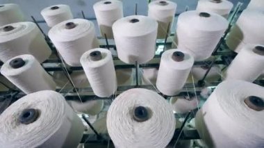 Büyük bobinler bir tekstil fabrikasında modern bir donanıma otomatik olarak biriktirilir.