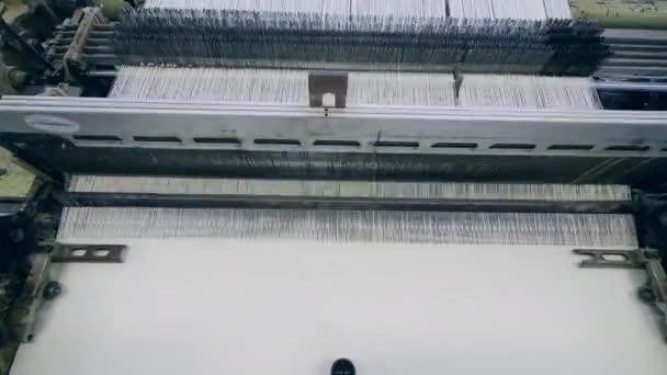 Fabryka maszyn włókienniczych pracuje z białym włóknem, szycie. — Wideo stockowe