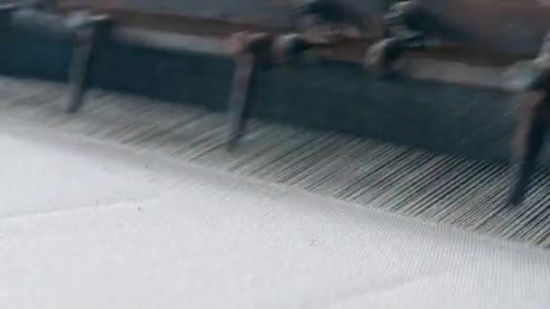 Witte stof genaaid op een machine in een textielfabriek. Productielijn industriële textiel. — Stockvideo