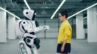 Bir kişi ve cyborg el dokunmadan, bir odada birbirlerine yakın ayakta.