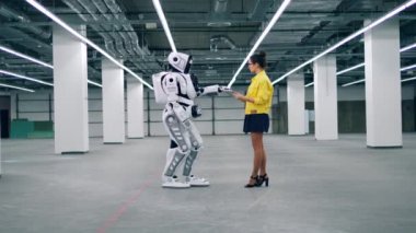 Genç kadın bir Droid kontrol, bir tablet kullanarak.