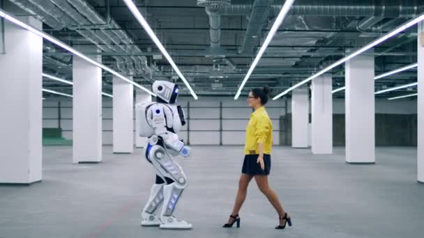 Droid e uma mulher se abraçam, de pé em uma sala . — Vídeo de Stock