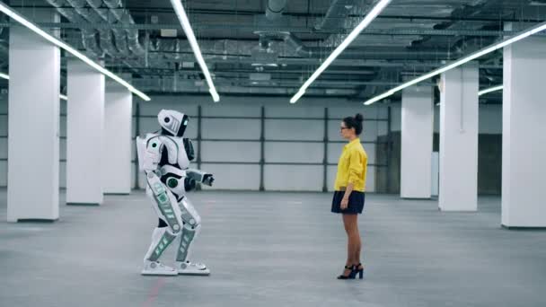 Android touche une main de filles, debout dans une pièce ensemble . — Video