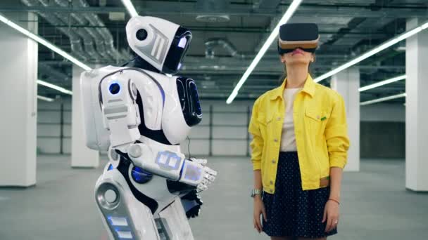 Vrouw in vr bril raakt witte robots hand. — Stockvideo