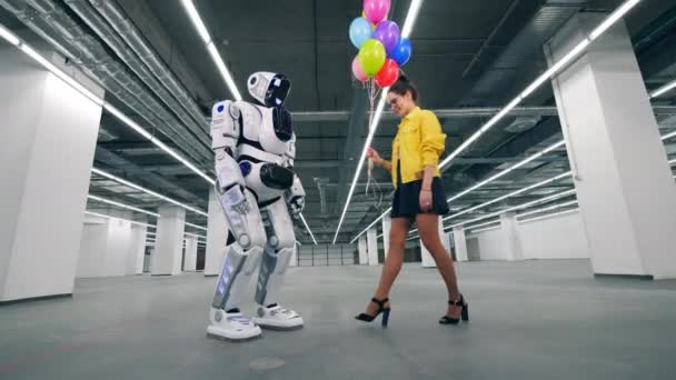 Nowoczesny Robot odbiera wiele balonów od dziewczyny. — Wideo stockowe