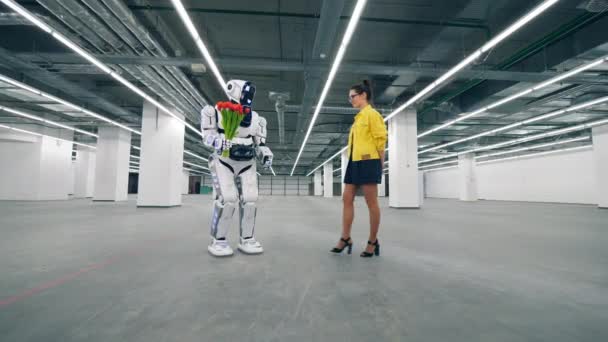 Přátelský robot se k mladé ženě s červenými tulipány. — Stock video