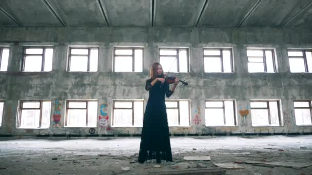 Hermosa mujer está tocando el violín en una habitación abandonada — Vídeo de stock