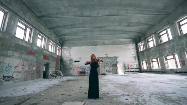 Gorgeous violinist is playing the instrument in an unkempt building — Stock Video