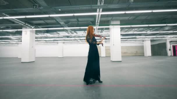 Salle vide et une femme jouant du violon tout en marchant — Video