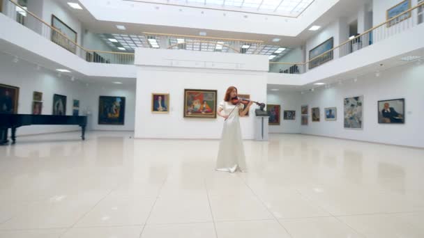 Violinista feminina está tocando o instrumento na galeria — Vídeo de Stock