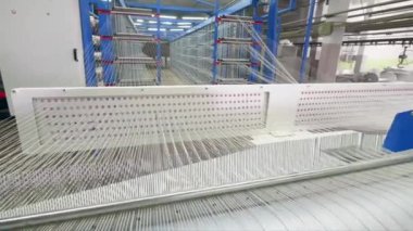 Fabrika tezgahı bir tesis odasında beyaz lif dokuma.
