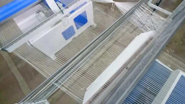 Υφαινοεξοπλισμός πλέκει χορδές των ινών σε ένα κλωστοϋφαντουργικό εργοστάσιο. — Αρχείο Βίντεο