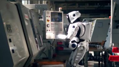 İnsan benzeri cyborg konsol üzerinden ekipman düzenliyor