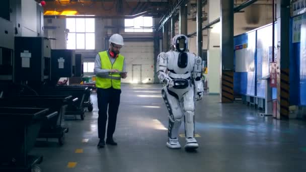 Técnico masculino está gerenciando um robô pelo tablet — Vídeo de Stock