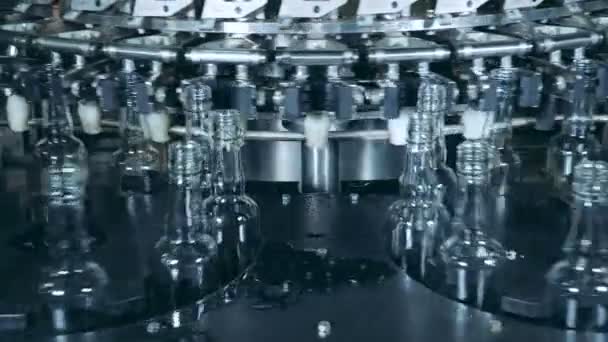 두 개의 원형 컨베이어 기계가 유리 병을 재배치하고 있습니다. — 비디오