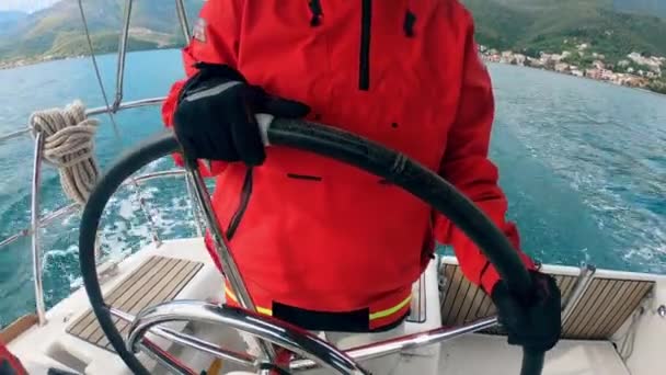 Une femme conduit un yacht à travers un lac — Video