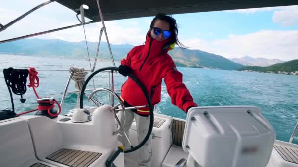 Yacht is zeilen over het water terwijl wordt gecontroleerd door een dame — Stockvideo