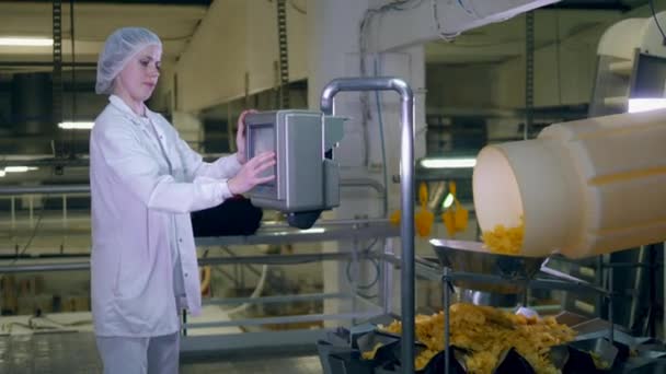 Lady especialista está regulando uma máquina de produção de chips — Vídeo de Stock
