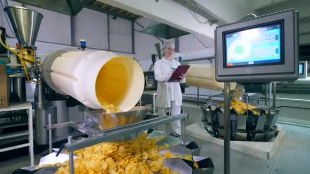 Experta femenina está observando el proceso de producción de patatas fritas — Vídeos de Stock