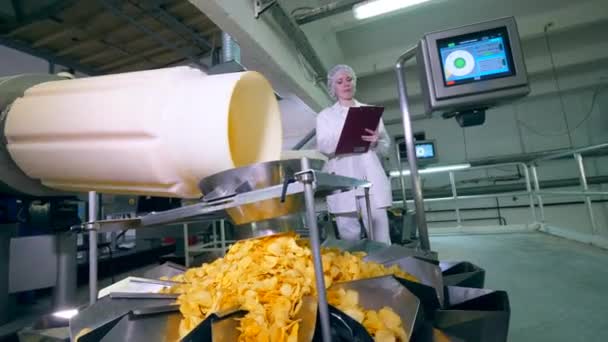 Kicsomagolt chips szállítják ellenőrzés alatt egy női munkás — Stock videók