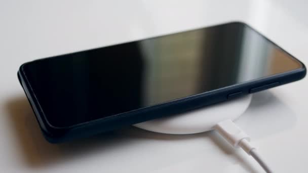 Mobile phone and a wireless charging device. Wireless charging concept. — Stock Video