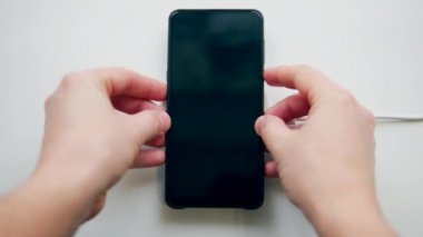 Beyaz şarj bloğu bir cep telefonuna güç veriyor. Kablosuz şarj kavramı.