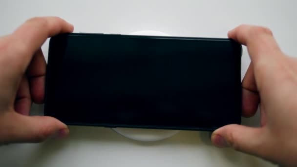 Smartphone wordt op de draadloze oplader gezet — Stockvideo