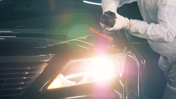 Um carro com as luzes acesas está a ser polido. — Vídeo de Stock