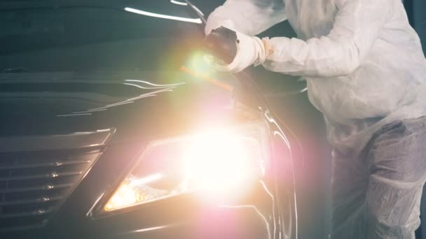 Serviceman está puliendo un coche negro con una rueda de tope — Vídeo de stock