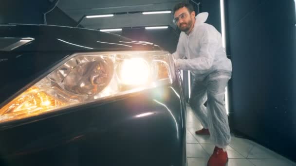 Männerspezialist benutzt ein Tuch, um ein Auto zu glasieren — Stockvideo