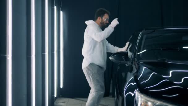 Dançando serviceman está limpando um carro em uma garagem — Vídeo de Stock