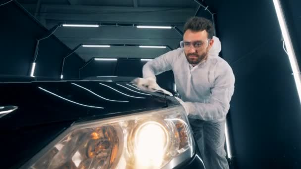 Tankstelle und ein Mann, der ein Auto mit einem Tuch säubert — Stockvideo