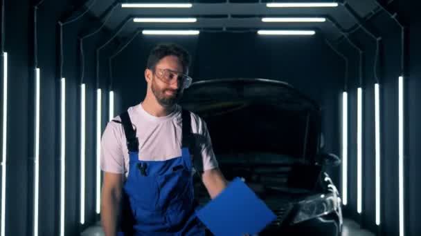 Mannelijke garage arbeider dansen met gereedschap en een Klembord in zijn handen — Stockvideo