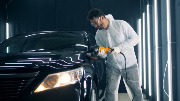 Serviceman is polishing cars wing with a professional tool — Stock Video