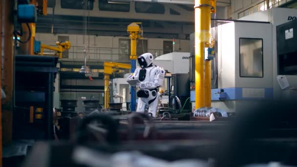 Tipos de cyborg blanco en una tableta mientras está de pie en una instalación . — Vídeos de Stock
