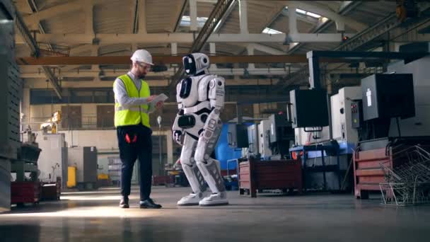 Ingeniero masculino enciende un droide mientras trabaja con una tableta . — Vídeos de Stock