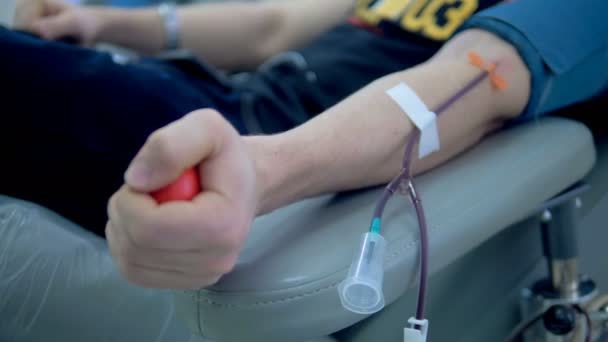 In einem Krankenhaus wird Blut aus den Händen von Menschen abgepumpt. Blutspendekonzept. — Stockvideo