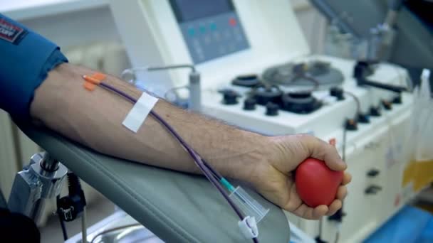 Male donor is giving blood while lying in a chair — Stock Video