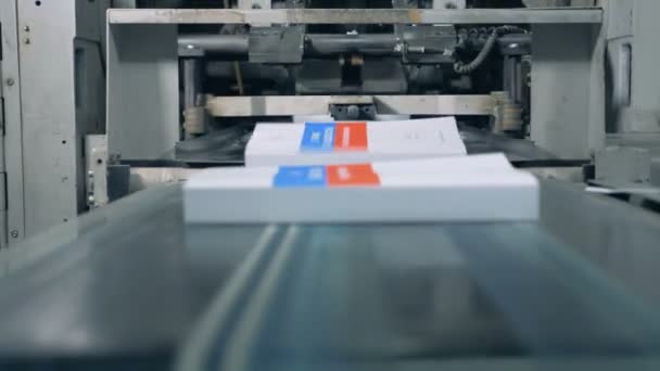 Veel boeken verplaatsen op een transportband in een print Office, moderne technologie. — Stockvideo