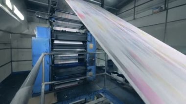 Bir baskı ofisinde bir satır üzerinde hareket eden uzun kağıt levhalar, iş yerinde fabrika ekipmanları.