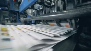 Otomatik bir kemer, tipografik makine üzerinde katlanmış gazete.