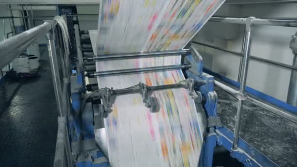 Newspaper pages rolling on mechanical conveyor at a print office. — Stock Video