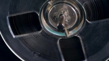 Makara kaydedici bant ile bir bobin döner.