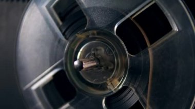 Bir müzik çalar üzerinde bant ile plastik bir makara döner.