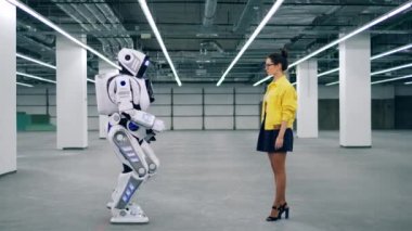 İnsan benzeri robot bir kızla el ele tutuşuyor.