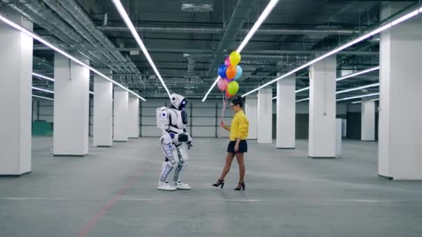 Ciborgue humano e uma mulher seguram balões. — Vídeo de Stock