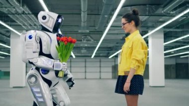 Genç bayan bir robottan lale alıyor.