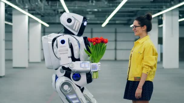 Tall robot geeft bloemen aan een opgewonden meisje — Stockvideo